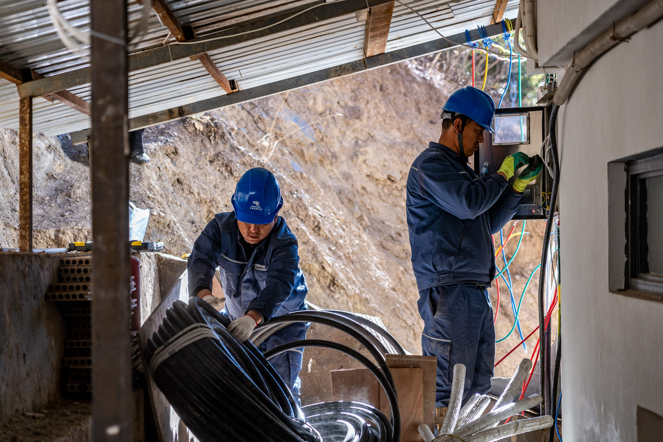Wangden inspects power lines for a hotel with his colleague in Yubeng Village, Deqen County, Yunnan Province
